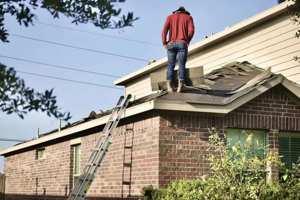 Roofer replacing damaged shingles on a residential roof – Roof Repair Westchester.