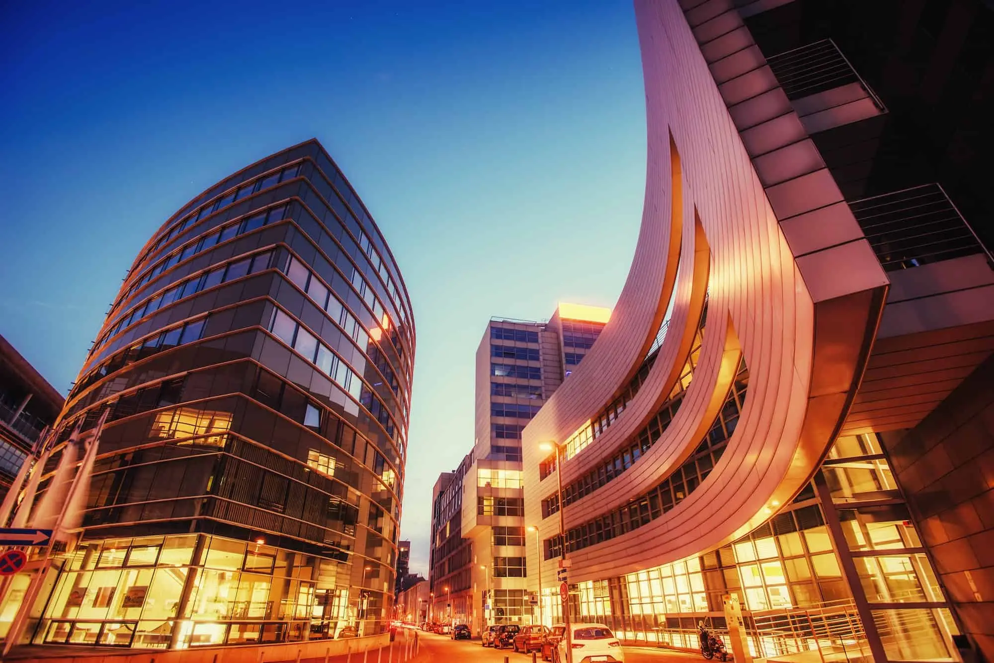 Curved modern office buildings at sunset in Westchester cityscape – Roof Repair Westchester commercial services.